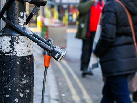 Broad Street, Oxford, United Kingdom, January 22, 2017: U-lock secure bicycle locks on light post on Broad street, Oxford city centre, Englandのeditorial素材