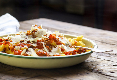 Italian durum wheat semolina egg pasta with tomato sauce, smoked pancetta, roasted almonds and parmesan cheeseの写真素材