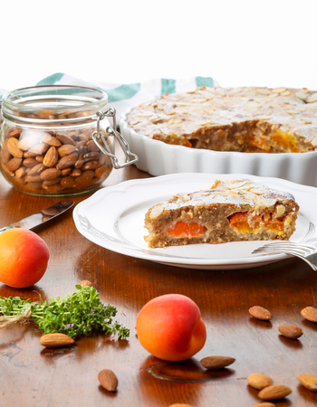 Crustless apricot frangipane tart with almonds and aromatic lemon thyme on rustic brown pine tableの写真素材