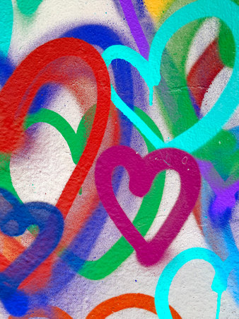 Vertical Close-Up of Colorful Graffiti Hearts on White Textured Wallの写真素材
