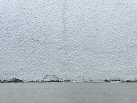 Aged Textured White Empty Wall with Worn Base and Concrete Floor, Grunge Background Mockup