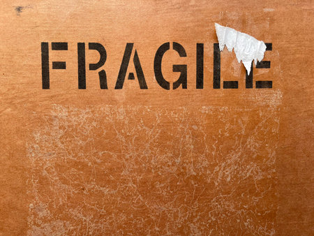 Close-Up of "Fragile" Text on Cardboard Box Backgroundの写真素材