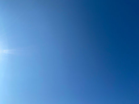 Clear Blue Sky with Subtle Sunlight and Gradient Atmosphereの写真素材