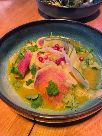 Colorful Gourmet Salad with Radish, Pomegranate, and Herbs in Citrus Dressingの写真素材