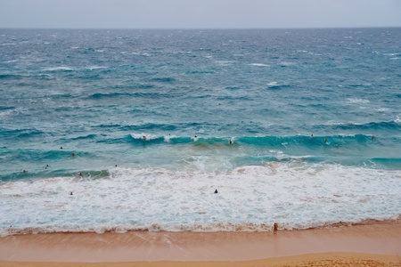 Crowded Beach in Oahu Island Hawaii. Surfers riding wavesの写真素材
