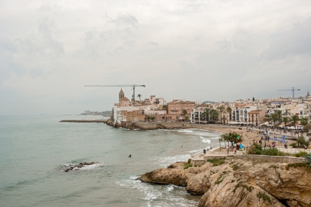 Sitges, Spain - September 28  Beautiful beaches in Sitges on the background Church of Sant Bartomeu   Santa Tecla  People enjoy water on a sunny day on September 28, 2013 のeditorial素材