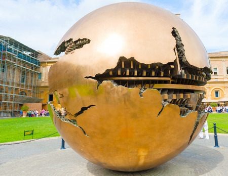 Vatican city, Vatican - September 22, 2014:  Tourists walk in the Courtyard of the Pine Cone in Vatican Museums. The Metal globe statue in the courtyard of pine cone.のeditorial素材