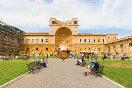 Vatican city, Vatican - September 22, 2014:  Tourists walk in the Courtyard of the Pine Cone in Vatican Museums. The Metal globe statue in the courtyard of pine cone.のeditorial素材