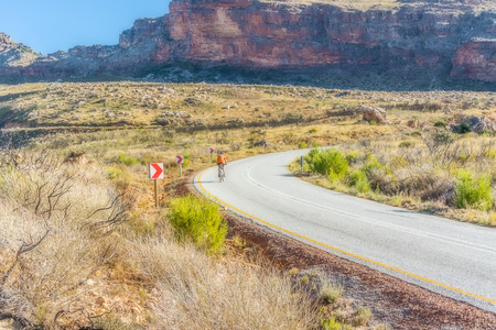 The Pakhuis Pass, South Africa - May 6, 2015: Cyclist riding the bike through The Pakhuis Pass . Th Pass lies roughly 20 kilometres outside of Clanwilliam with incredible views from the top of the pass onto the Karoo.のeditorial素材