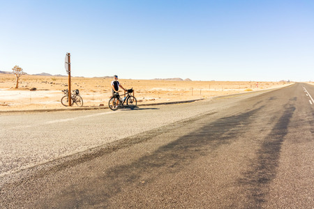 Cyclist at the stop sign at N7 road near Vioolsdrif in South Africaのeditorial素材
