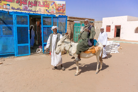 Sahara desert, Sudan - January 24, 2015: Man riding a donkey in the desert village near Dongola in Sudanのeditorial素材