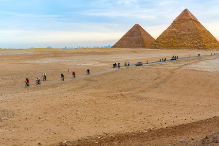 Cairo, Egypt - January 9, 2015: Pyramids in Giza and people riding bicycles.のeditorial素材