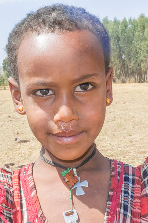 Dangla, Ethiopia - February 13, 2015: Close up picture of the young girl staying by the road. Picture was taken when riding on the road near Dangla in Ethiopia.のeditorial素材