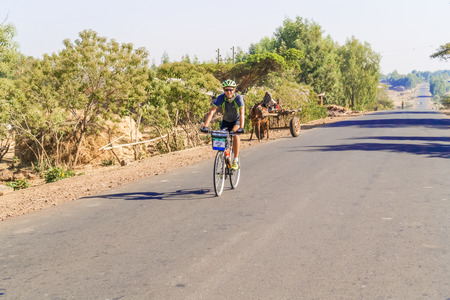 Bahir Dar, Ethiopia - February 11, 2015: Man riding bicycle through small village near Bahir Dar in Ethiopiaのeditorial素材