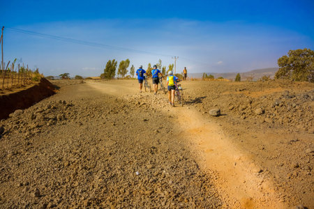 Hagere Maryem, Ethiopia - February 24, 2015: People on bicycles riding on the road near Hagere Maryem in Ethiopiaのeditorial素材