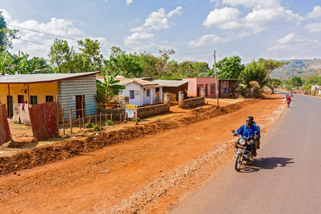 Gwangwa, Ethiopia - February 23, 2015: Man is riding motorbike through small village of Gwangwa in Ethiopia.のeditorial素材