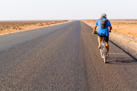 Marsabit, Kenya - March 1, 2015: Man on bicycle cycling on Marsabit Moyale road in Kenya.のeditorial素材