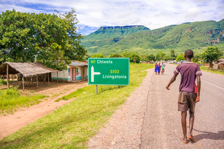 Khondowe, Malawi - March 24, 2015: People walking on the road in small village in Khondowe, Malawi. The village is located near lake Malawi.のeditorial素材