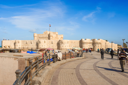 Alexandria, Egypt = January 2, 2015: People walking by the walls of Qaitbay Castle or Citadel with Egyptian flag in Alexandria, Egypt. It  is a 15th-century defensive fortress on the Mediterranean coast established in 1477 AD by sultan Qaitbayのeditorial素材
