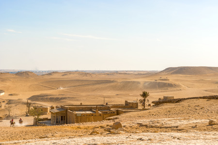 Cairo, Egypt - December 31, 2014: Desert landscape with people on horses near Giza Pyramids in Cairo, Egypt.のeditorial素材