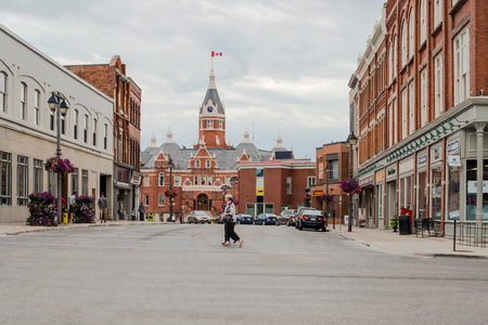 Stratford, Canada - August 8, 2015: People crossing the street and the town hall building in the city of Stratford in Ontario at the backgroundのeditorial素材