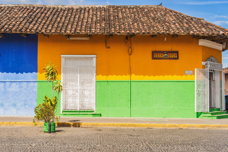 Granada, Nicaragua - November 20, 2016: Street view at the facade of colorful commercial houses in...