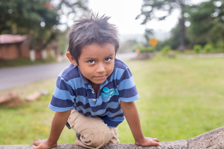 Valle de Angeles, Honduras - November 26, 2016: Portrait of the young boy climbing the fence. It was taken in Valle de Angeles in Honduras.のeditorial素材