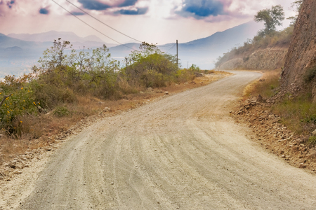Dirt road to San Luis Jilotepeque in Guatemala and the mountains at the background.の写真素材