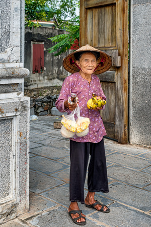 Hoa Lu, Vietnam - October 28, 2017: Woman is selling bananas at the entrance to ancient capital of Vietnam Hoa Lu. It was the capital city in the 10th and 11th centuries.のeditorial素材