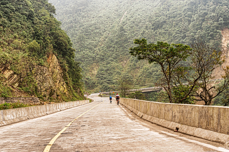 Bicycle riders on the road  in Vietnam near the border with Laos at Nam Phao.の写真素材