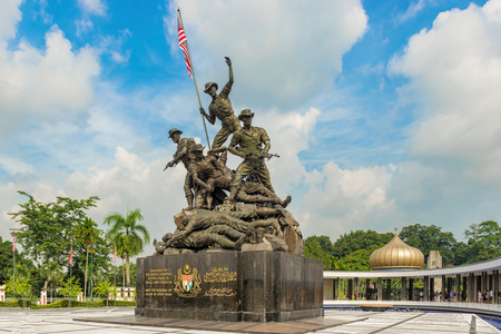 Kuala Lumpur, Malaysia â Dec 14, 2017: Tourists visiting National Monument, sculpture that commemorates those who died in Malaysia struggle for freedom, against Japanese during World Wars.のeditorial素材