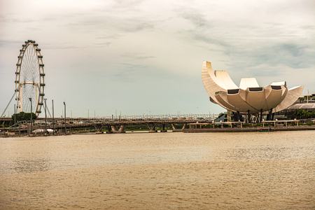 Panoramic view at the iconic structures in downtown Singapore, the Flyer, Helix Bridge, and flower shape design of Art Science museum as seen from the Singapore river.のeditorial素材