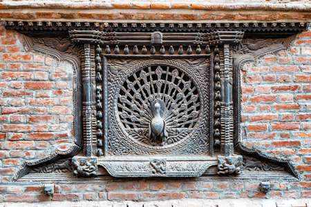 View at carved wooden Peacock Window, Tachupal Tole, Pujari Math in Bhaktapur, Kathmandu valley, Nepal.の写真素材