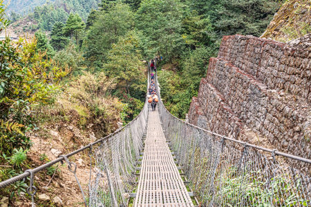Phakding, Nepal - October 25, 2018: Trekkers on the hanging bridge at Everest Base Camp trek between Lukla and Phakding.のeditorial素材