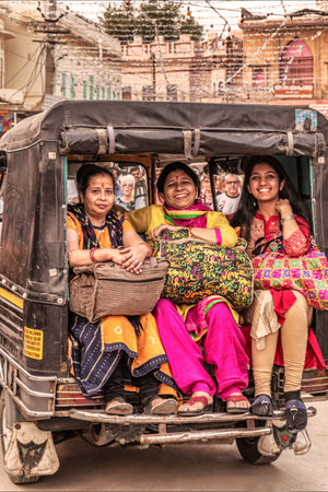 Pushkar, India - Nov 15, 2018: Three local woman riding thru the streets of Pushkar at the back of Tuk Tuk, Rajasthan, India.のeditorial素材