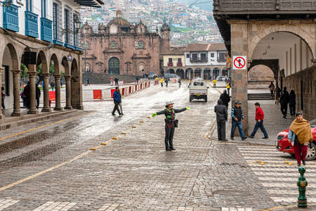Cusco, Peru - April 3, 2019: Police woman directing traffic at the corner of Av. El Sol and Marquez Mantas street leading to Plaza Armas the centre point of  Cusco city, Peru.のeditorial素材