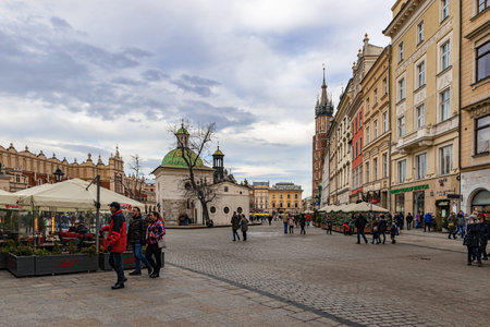 Cracow, Poland â Feb 2, 2019: Tourists at main square passing by The Church of St. Adalbert or of St. Wojciech, the 11th century church in Cracow, Poland.のeditorial素材