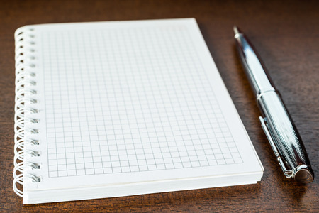 Notebook with a pen on the wooden tableの写真素材
