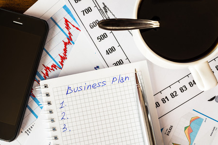Work in the office, coffee cup with business planの写真素材