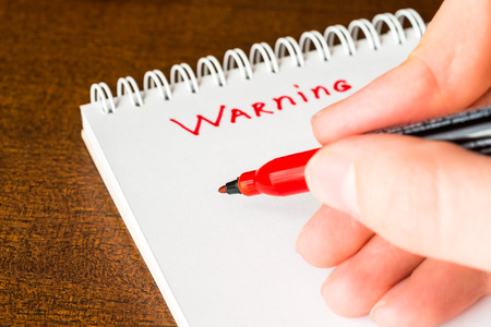 Warning, sign in the notebook by red markerの写真素材