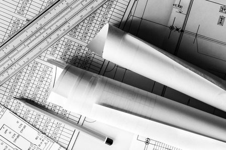 Rolls of drawings with the pencil and slide rule on the scheme. In hard black and white tonesの写真素材