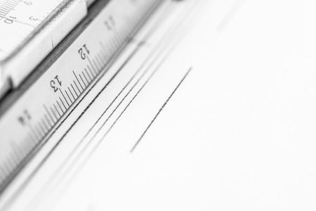 Schemes and slide rule on the table. Angle view close-up, in black and white tonesの写真素材