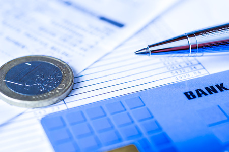 Pay the bills, bank card and pen with check on the table. In blue tonesの写真素材