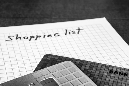 Planning purchases, a notebook with shopping list and a credit cards on the table. In black and white tonesの写真素材