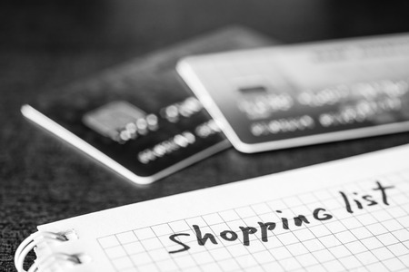 Shopping list, a notebook with shopping list and a credit cards on the table. In black and white tonesの写真素材