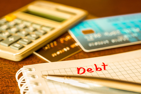 Debt payments, the calculation of the balance, a credit cards and a calculator on the table. In yellow tonesの写真素材