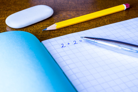 Studying in the school, solving mathematical problems, a pencil and eraser on the table. In blue tonesの写真素材