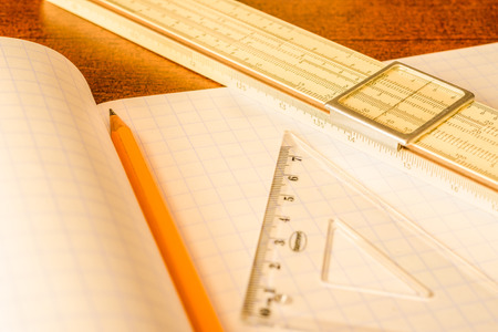 Schemes the pencil and triangle with slide rule on the table in the school. In yellow tonesの写真素材