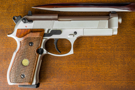 The knife and the pistol on the table. Top viewの写真素材