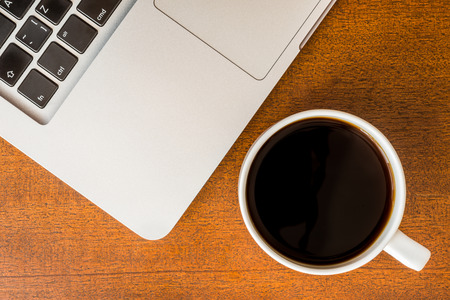 Work in the office, coffee cup with laptop  on the wooden tableの写真素材